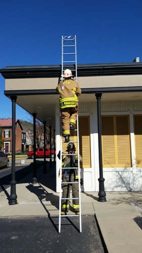 Firefighters on a ladder getting a check.